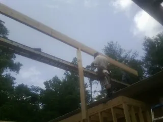 Carpenter setting a ridge beam over a new addition frame — Ice Dam Removal by Roofing Brothers in Bozrah
