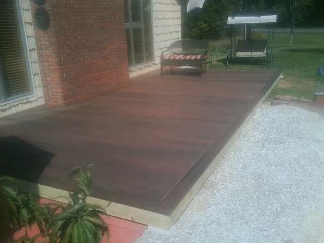 Freshly stained wood deck built against a brick home in Bozrah