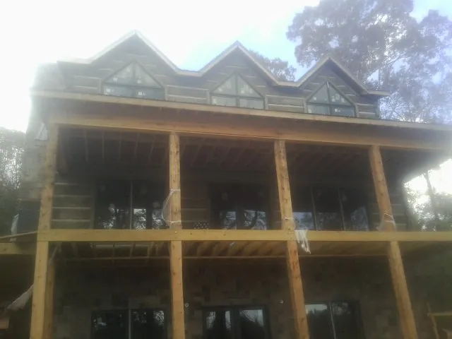 Dormers and porch framing on a large log home under construction — Roof Coating work by our crew in Bozrah