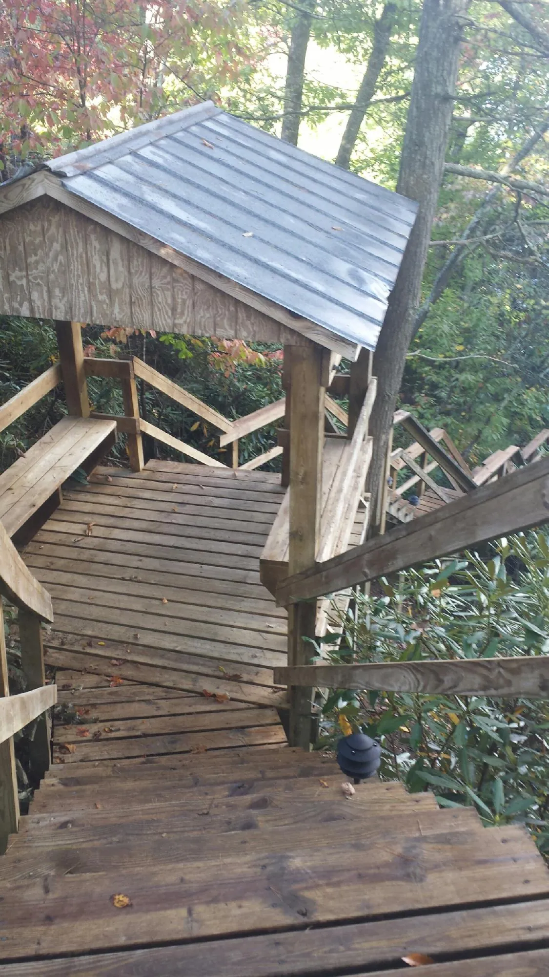 Metal roofed shelter over wooden steps on a wooded walkway — Skylight Repair & Installation work by our crew in Bozrah