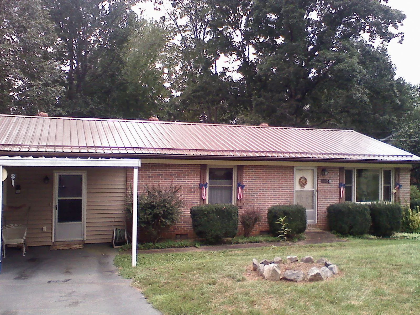 Bronze metal roof and carport on a brick ranch home — Roof Repair work by our crew in Bozrah